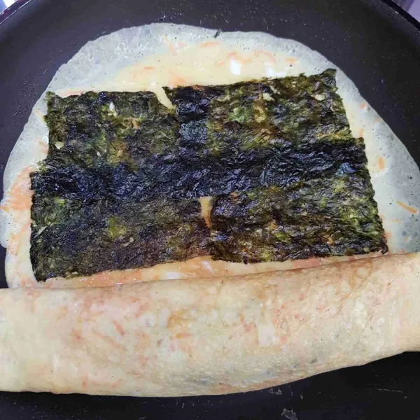 Tuang lagi sisa adonan telur, ratakan dan beri 4 lembar nori. Masak hingga sedikit kering kemudian gulung dan padatkan.