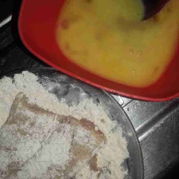 Balurkan ayam ke dalam tepung ayam goreng instan, lalu balurkan ke dalam telur.