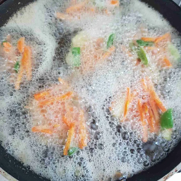 Panaskan minyak dalam wajan. Kemudian goreng adonan tempura, sendoki adonan tempura dengan sedikit meniriskan cairan tepungnya. Goreng hingga matang kecoklatan.