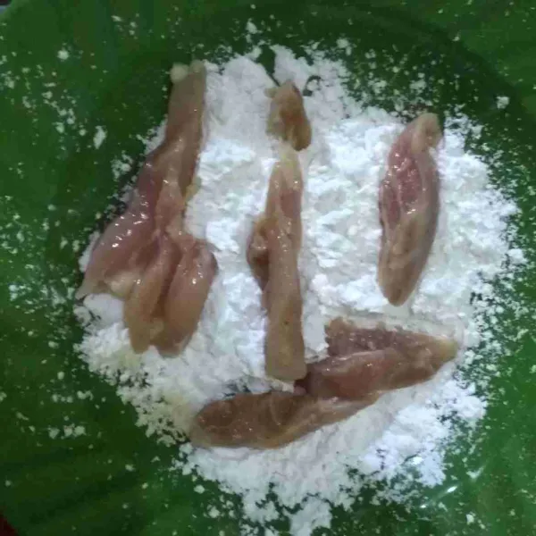 Keluarkan daging ayam dari kulkas kemudian balur dengan tepung sagu hingga rata.