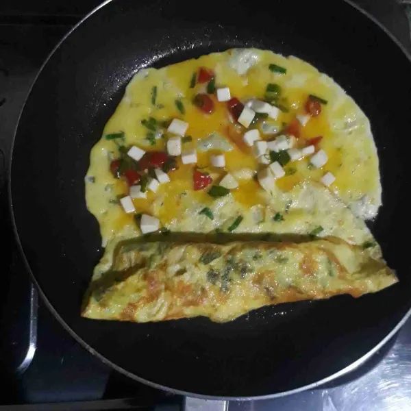 Setelah mulai matang, gulung telur sisakan sedikit bagian. Tuangkan 1/3 telur berikutnya. Setelah mulai matang lalu gulung kembali. Lakukan sampai telur habis.