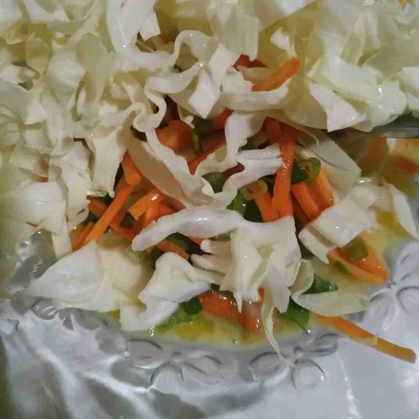 Masukkan sayuran yang terdiri dari kubis, wortel, daun bawang, dan bawang putih, aduk rata.