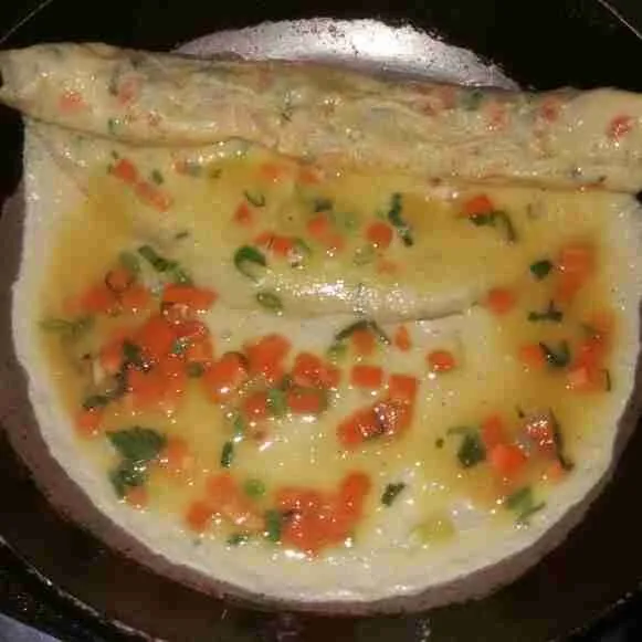 Tuang 1/4 bagian telur lagi, masak 1 menit lalu gulung kembali.