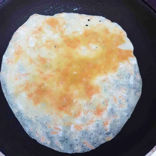 Panaskan teflon dengan sedikit minyak kemudian tuang sedikit adonan telur dalam teflon dan ratakan.