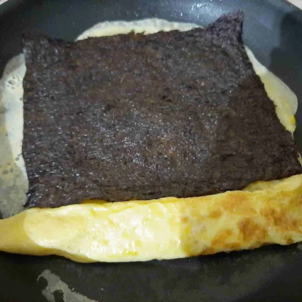 Tuang lagi adonan telur lalu tata nori diatasnya, gulung kembali.