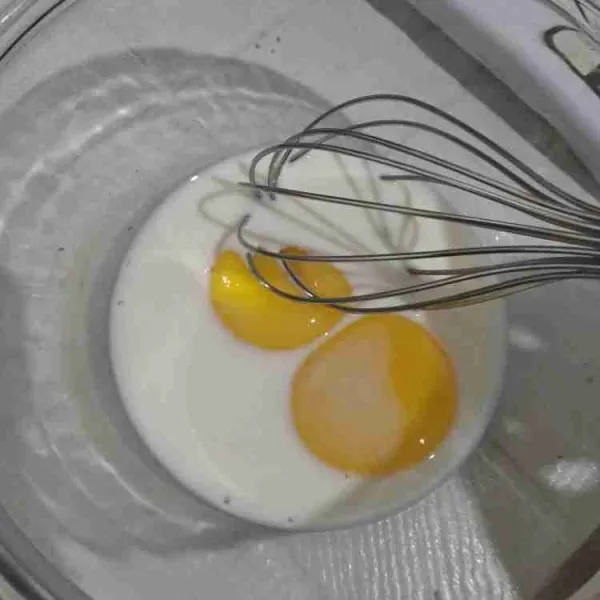 Kocok kuning telur dan susu hingga tercampur rata dengan menggunakan whisk, sisihkan.