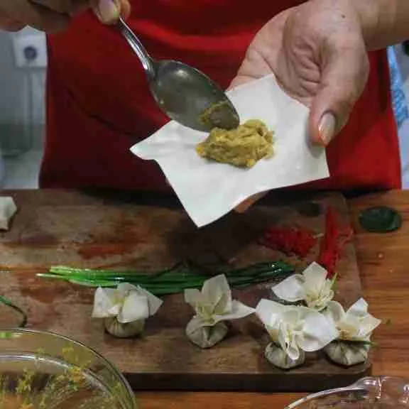 Isikan pada kulit pangsit lalu ikat dengan daun bawang, lakukan sampai pangsit habis.