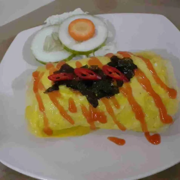 Bungkus nasi dengan omelet. Tambahkan nori diatasnya sebagai pelengkap kemudian sajikan.