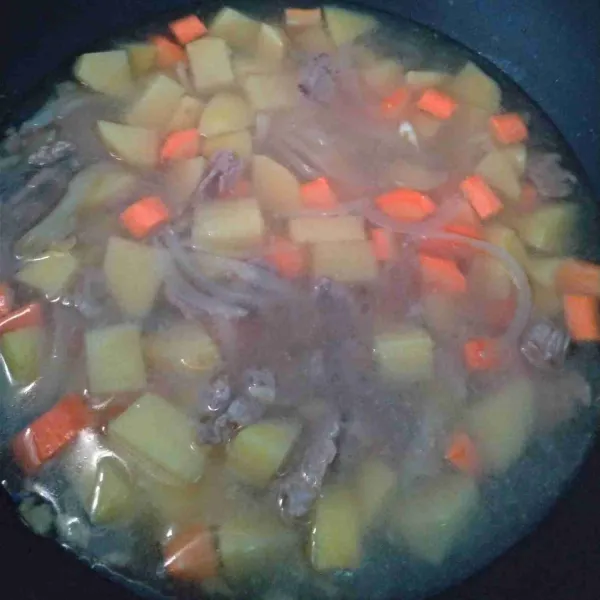 Masukkan wortel dan kentang, tambahkan air, masak hingga empuk.