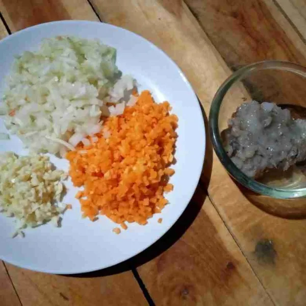 Cincang bawang putih, bawang bombay, dan wortel.