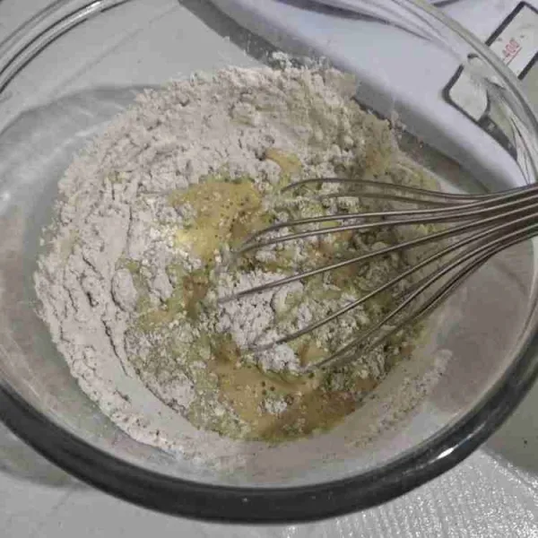 Masukkan campuran tepung terigu ke dalam adonan kuning telur, aduk rata.