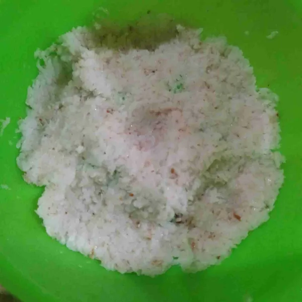 Olesi cetakan dengan minyak, kemudian beri secukupnya kelapa dengan sedikit ditekan-tekan.