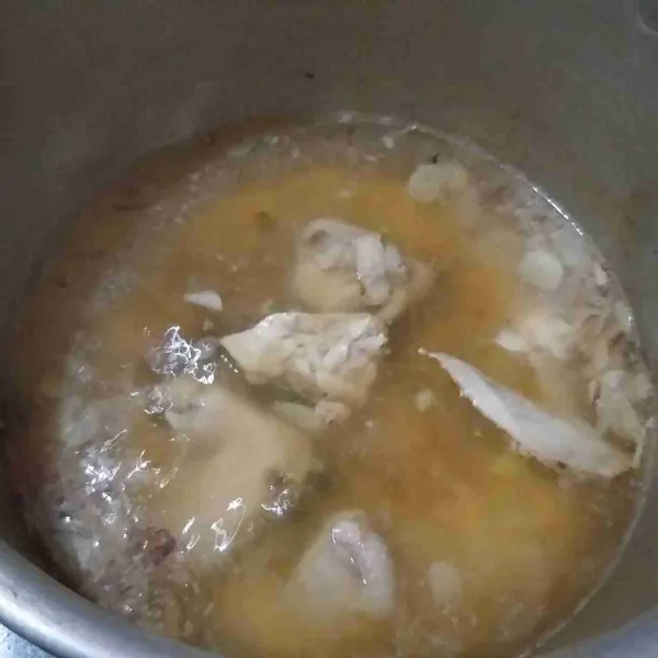 Panaskan minyak untuk menumis, kemudian tumis bawang merah dan bawang putih hingga harum, tambahkan air, dan masukan ayam, biarkan hingga mendidih dan minyak kaldu keluar dari ayam.