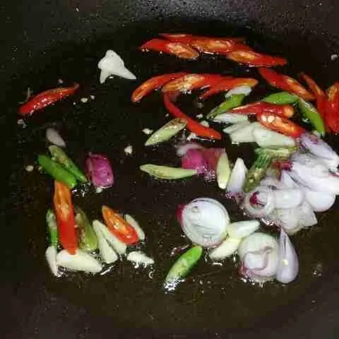 Tumis bawang merah, bawang putih, cabe merah besar, dan cabe rawit yang sudah diiris sampai layu.