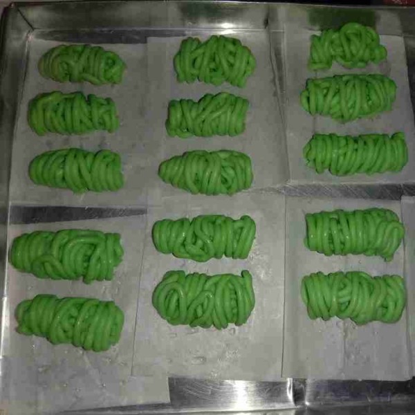 Kemudian masukkan adonan ke dalam plastik segitiga, gunting ujungnya kecil saja (bisa juga memakai cetakan putu mayang). Cetak adonan diatas daun pisang yang dioles sedikit minyak atau diatas baking paper.