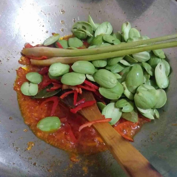 Setelah bumbu matang, masukkan cabe iris dan petai kupas, salam, sereh dan daun jeruk. Masak sampai cabe dan petai layu.
