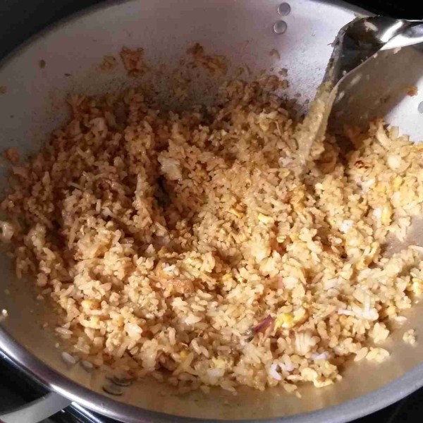 Besarkan api, masak nasi hingga menyatu dengan bumbunya dan tercium aroma sedap. Jika sudah matang, nasi goreng siap disajikan dengan acar.