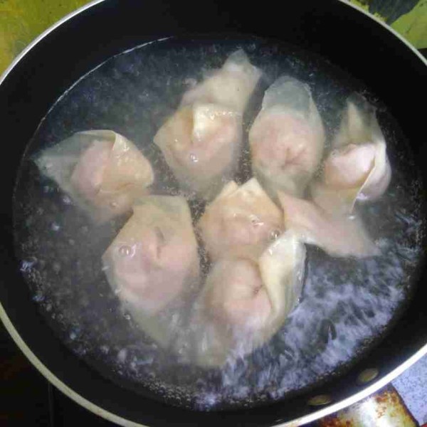 Siapkan air mendidih. Rebus sebentar caisim sisihkan. Ini dilakukan terlebih dahulu karena air masih bersih dan tidak mengental, selanjutnya rebus pangsit hingga mengapung.