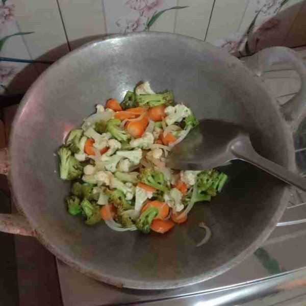 Masukkan wortel, kembang kol, dan brokoli kemudian masak hingga setengah matang.