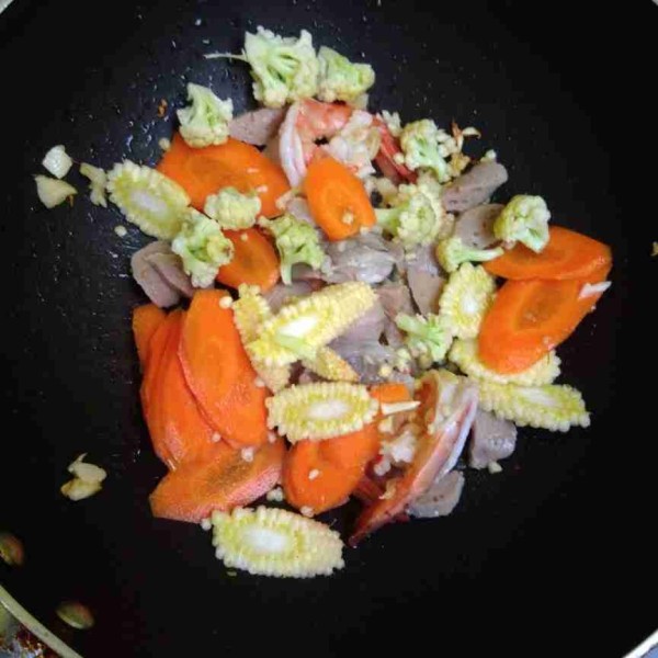 Masukkan wortel, jagung muda, dan bunga kol. Angkat udang sebentar supaya tidak over cooking. Tambahkan air, masak sayuran hingga empuk.