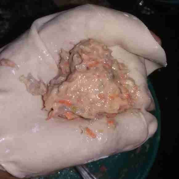 Ambil selembar kulit siomay yang telah dibuat sebelumya, beri 3/4 sendok isian. Bungkus lalu beri topping wortel serut di atasnya, lakukan hingga bahan isian dan kulit habis.