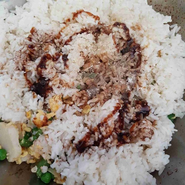 Masukkan bahan saus. Aduk rata dan masak menggunakan api sedang cenderung besar hingga nasi sedikit mengering. Koreksi rasa dan siap disajikan.