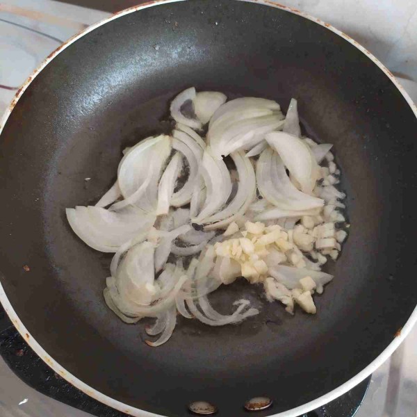 Panaskan minyak di dalam wajan anti lengket, tumis bawang bombay, dan bawang putih hingga layu dan harum.