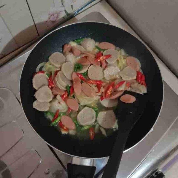 Buat capcay dgn panaskan margarin, tumis bawang putih, dan bawang bombay hingga harum. Masukkan irisan bakso, sosis, cabai merah, dan cabai hijau tambahkan sedikit air.