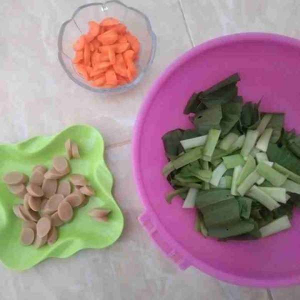 Potong-potong sayuran dan sosis lalu cuci bersih sayuran.