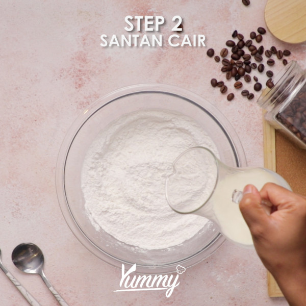 Tambahkan santan cair, perasa pandan dan setengah dari kelapa parut kedalamnya aduk kembali hingga tercampur rata.