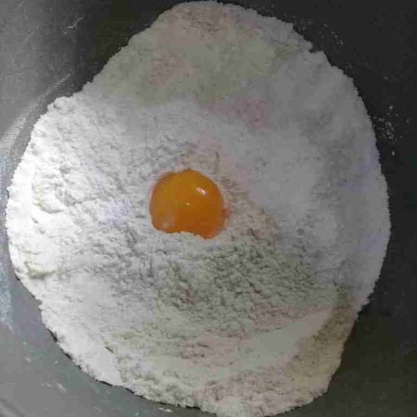 Masukkan tepung terigu protein tinggi, garam, dan gula pasir aduk rata, lalu masukan kuning telur.