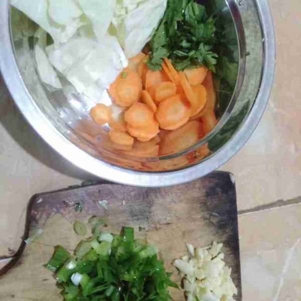 Potong sayur kol, wortel, daun sop, daun bawang dan bawang putih.