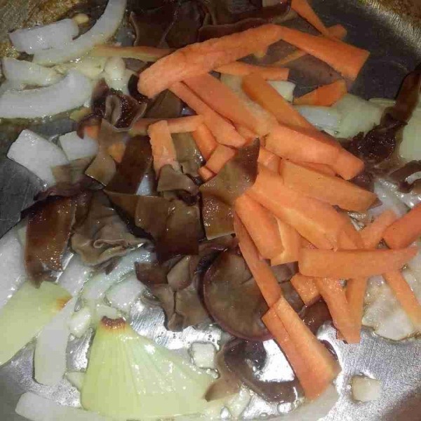 Masukkan jamur kuping dan wortel.