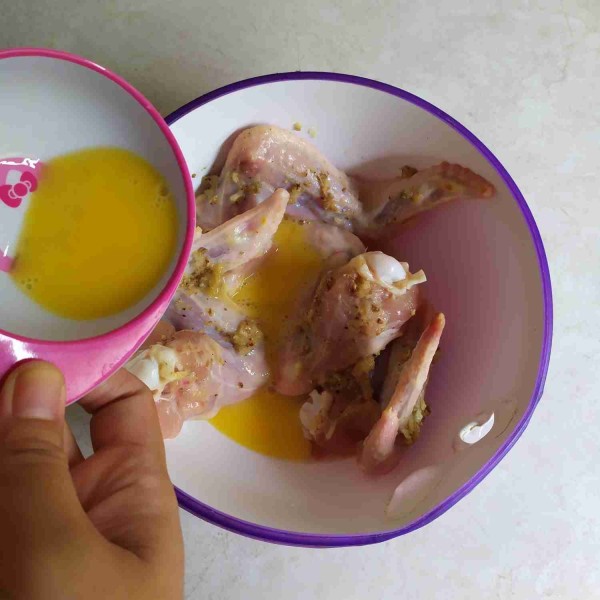 Keluarkan sayap ayam dari kulkas lalu lumuri dengan kocokan telur.