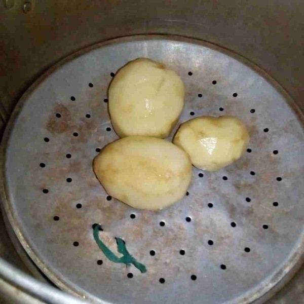 Kukus kentang yang telah dibersihkan sampai matang.
