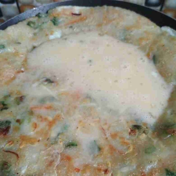 Balik adonan tambahkan sisa kocokan telur, tuang adonan telur sambil goyang kan teflon agar permukaan pancake rata dengan telur, masak hingga matang.