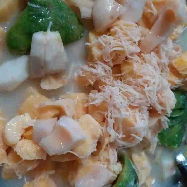Campur semua buah, tapai singkong, beri sirup, air secukupnya, krimer kental manis dan keju parut, aduk rata.