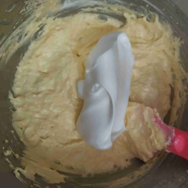 Masukkan adonan putih telur ke dalam adonan butter tadi secara bertahap, aduk balik menggunakan spakula plastik sampai rata.