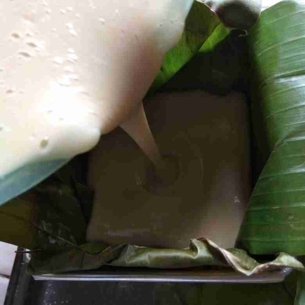 Siapkan wadah atau cetakan lapisi dengan daun pisang. Tuangkan adonan ke wadah atau cetakan.