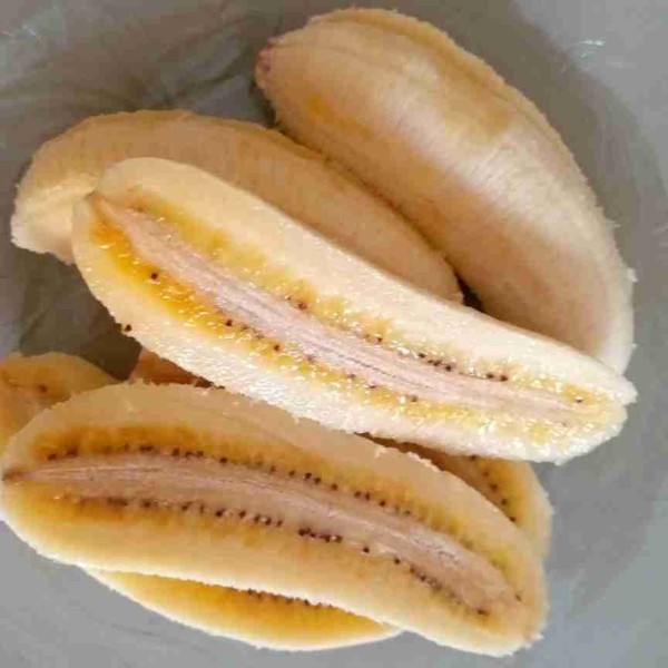 Kupas pisang lalu belah pisang menjadi dua bagian.