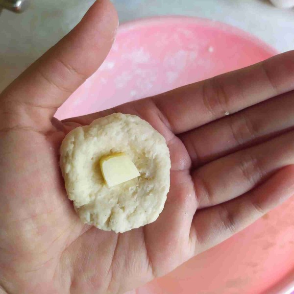 Ambil adonan secukupnya, lalu pipihkan. Beri satu potong keju kemudian bulatkan.