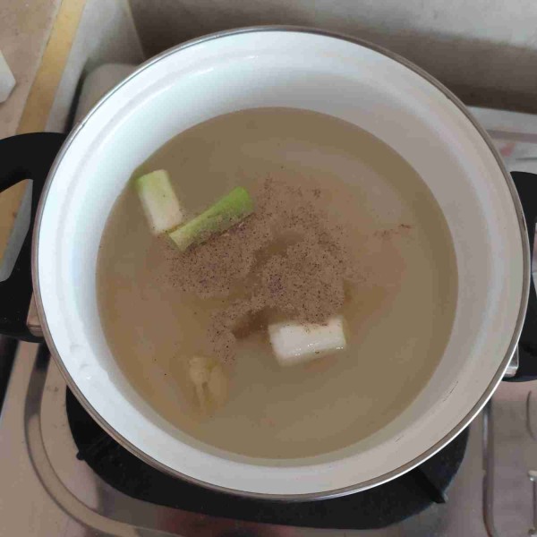 Buat kuahnya : masukkan air ke dalam panci, lalu tambahkan bawang putih geprek, batang daun bawang, dan beri bumbu garam, merica bubuk, kaldu blok, gula pasir, dan penyedap. Tunggu hingga mendidih. Jangan lupa cek rasanya.