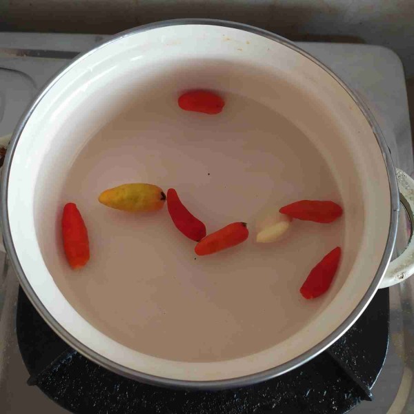 Buat sambalnya: rebus cabe rawit dan bawang putih yang telah dicuci bersih hingga bawang empuk.