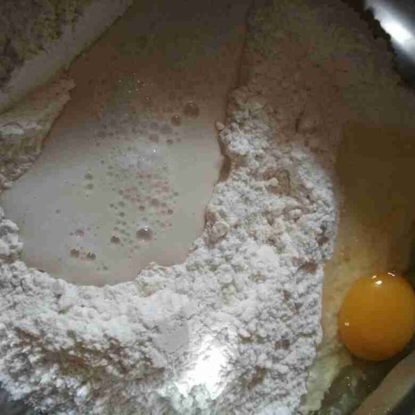 Siapkan wadah kemudian masukkan tepung terigu, susu bubuk, gula pasir, dan telur tuang bahan biang lalu aduk rata.