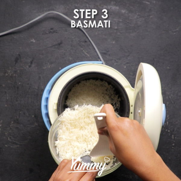 Campurkan basmati yang telah dicuci bersih, bumbu tandoori, garam, dan lada dalam rice cooker lalu aduk hingga tercampur rata.