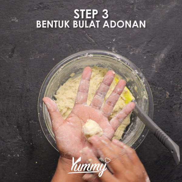 Ambil satu sdm adonan lalu pipihkan dengan tangan. Setelah pipih tambahkan coklat batang di bagian tengahnya lalu bentuk bulat dengan menggunakan tangan.