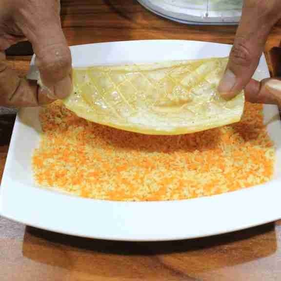 Guling-gulingkan cumi ke tepung roti hingga rata.