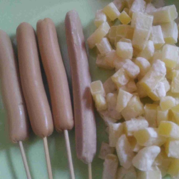 Tusuk sosis menggunakan tusuk sate dan potong kentang beku kecil-kecil.