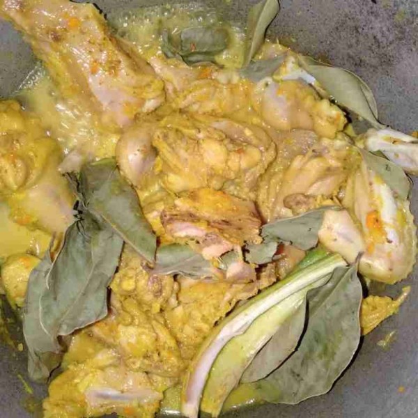 Masukkan daun salam dan sereh ke dalam rebusan ayam.
