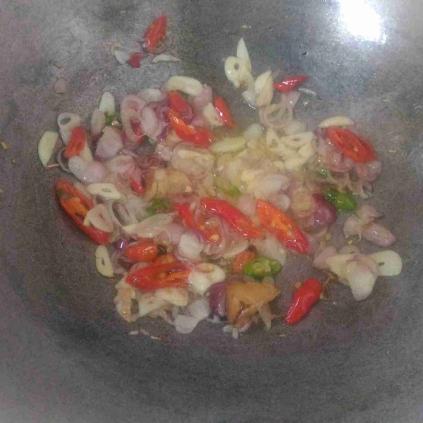 Tumis bumbu iris dan lengkuas sampai harum dan matang.